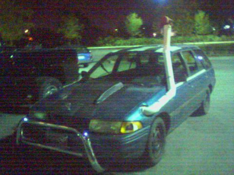 2001 Ford F-150 - A modified blue station wagon is parked at night, with a snorkel extending from the hood.
