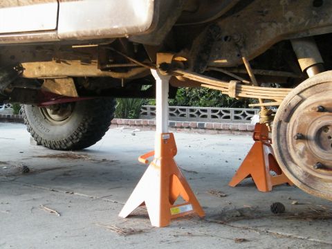 1982 Ford Bronco - The rear axle and suspension components are visible as the vehicle is supported by jack stands.