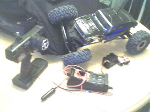 1989 Ford Bronco - A remote control rock crawler truck is shown on its side with its controller and electronic components.