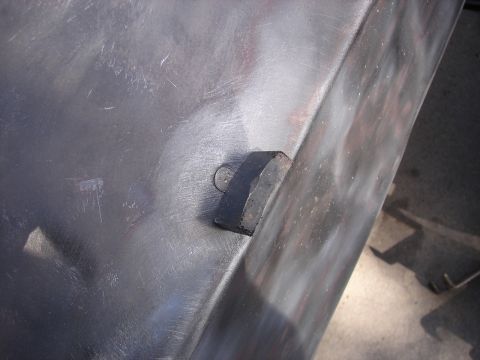 1973 Ford Ranchero - Close-up of a metal panel showing a bolt and bracket, with visible scratches and primer.