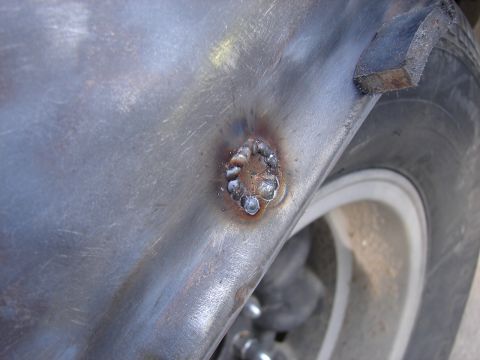1973 Ford Ranchero - Detail of a repair weld on the exterior metal of a vehicle, with a tire and wheel in the background.