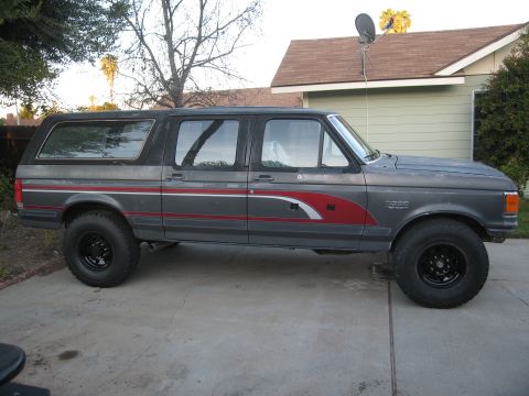 1986 Ford Bronco - This 1986 Ford Bronco features a two-tone gray paint scheme with red and white accent decals along the side.