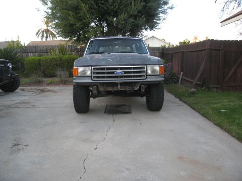 1986 Ford Bronco - Front view of a 1986 Ford Bronco with a grey exterior and modified bumper area.