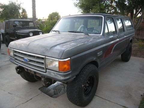 1986 Ford Bronco - This gray Ford Bronco, likely a 1987 model, is parked next to a black Jeep.
