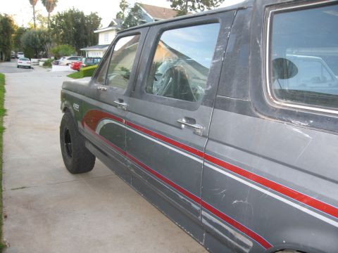 1986 Ford Bronco - This 1986 Ford Bronco displays its distinctive side profile with a gray paint job accented by red and white pinstripes.