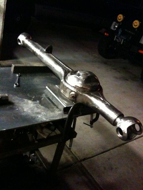 2009 Suzuki Samurai - Differential axle housing, likely for a Suzuki Samurai, on a workbench.