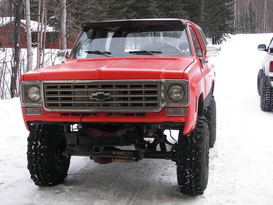 Red lifted 1973 Chevrolet K5 Blazer front view with large tires in snow