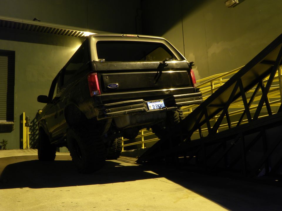 1995 Ford Bronco rear view, partially on a metal ramp at night