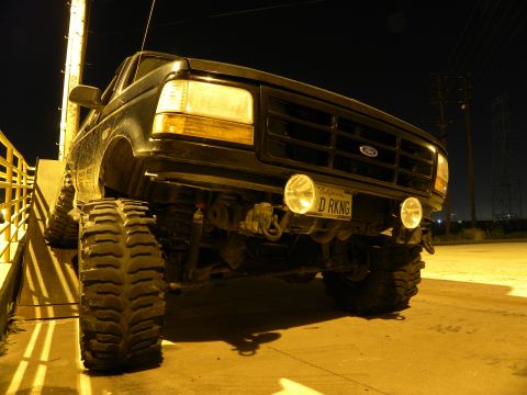 1995 Ford Bronco - A black 1995 Ford Bronco is shown from the front, lifted with oversized tires and a custom California license plate.