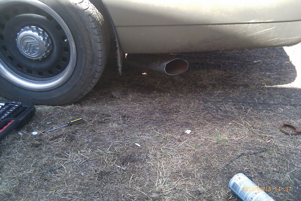Side view of a 2000 Mercury Grand Marquis showing the exhaust pipe and wheel with a Mercury badge