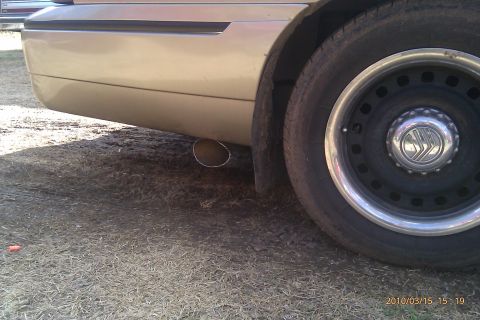 2000 Mercury Grand Marquis - Rear view of a 2000 Mercury Grand Marquis, showing the wheel and exhaust.