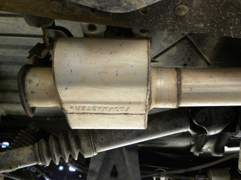 1995 Ford Bronco - Underside view of a Flowmaster muffler installed on a vehicle's exhaust system.