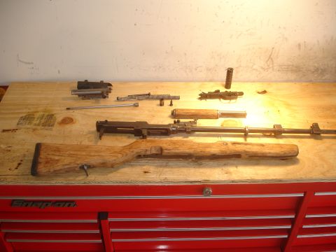 1989 Ford Bronco - Firearm components are organized on a workbench, suggesting a repair or assembly process.