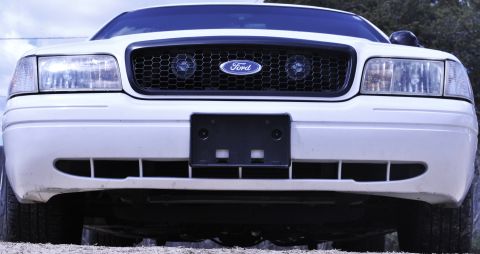 2002 Ford Crown Victoria - Front view of a white 2002 Ford Crown Victoria, highlighting its distinctive honeycomb grille and Ford emblem.