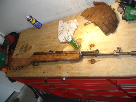 1989 Ford Bronco - An SKS rifle is laid out on a workbench with cleaning supplies and a glove.