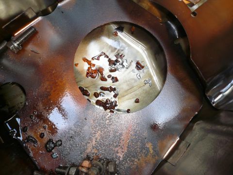 1975 Ford Ranchero - Engine oil pan interior shows metal debris and oil, indicating potential internal engine damage.