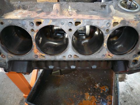 1975 Ford Ranchero - The internal cylinders of a rusty engine block are shown, with a drip pan collecting fluids.
