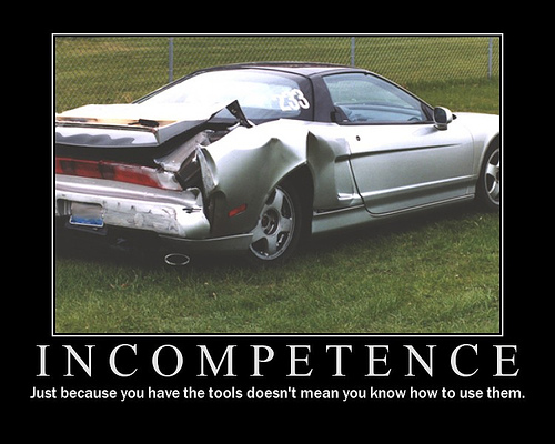 Silver sports car with significant rear-end damage, dented bumper, and crumpled quarter panel