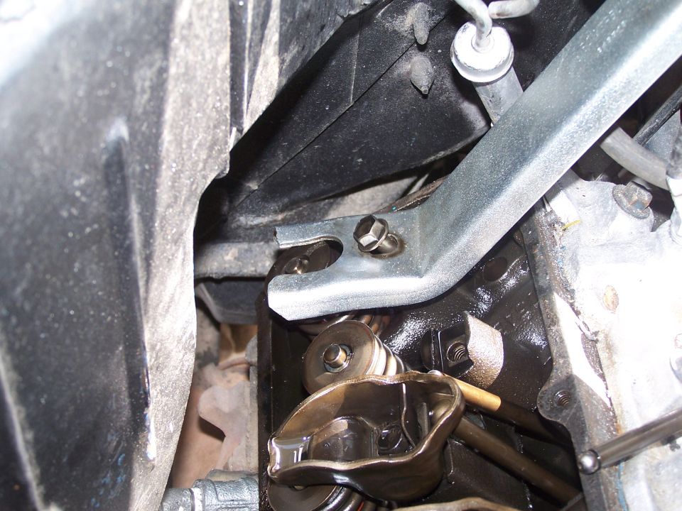 Close-up of engine valve train parts, including rocker arms and springs, with oil visible