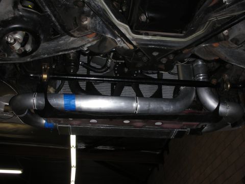 1992 Ford Crown Victoria - Custom intercooler piping is visible underneath a vehicle, suggesting modifications to the engine's air intake system.