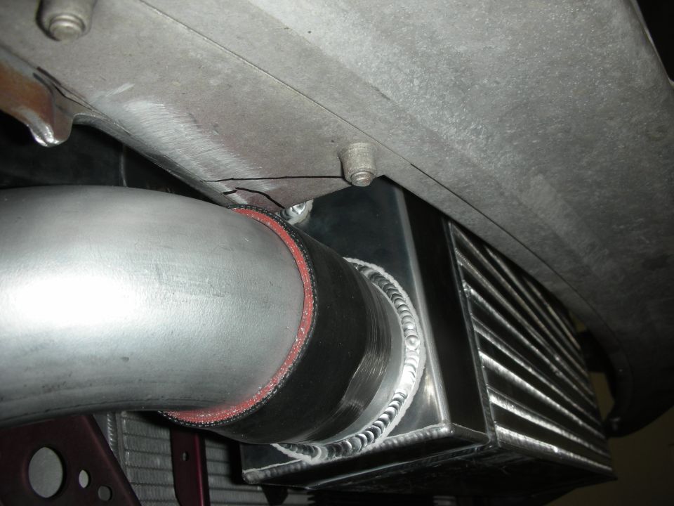 Close-up of intercooler piping connected to a new intercooler core with visible welds