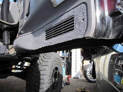 1996 Ford Bronco - Close-up view of a vehicle's interior door panel and a large tire, with another car visible in the background.