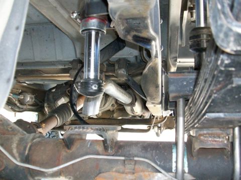 1996 Ford Bronco - A close-up view of the undercarriage reveals the vehicle's suspension system, including a shock absorber and leaf springs.