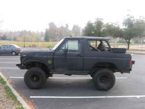 1991 Ford Bronco - This black Ford Bronco features a lifted suspension and aftermarket wheels, suggesting off-road modifications.