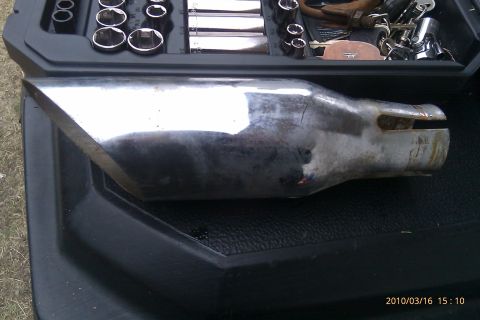 2000 Mercury Grand Marquis - A chrome exhaust tip with an angled cut is shown inside a toolbox with various sockets and tools.
