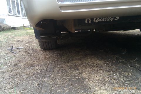 2000 Mercury Grand Marquis - A close-up view of a vehicle's rear tire and bumper, with a sticker visible on the frame.