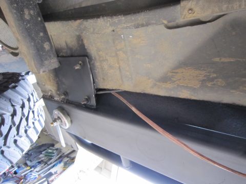 1996 Ford Bronco - Underside view of a vehicle's frame with a custom bracket and a large tire visible.
