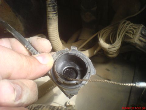 1998 Ford Crown Victoria - Close-up of a cruise control cable and its connector, with a hand holding the cable.