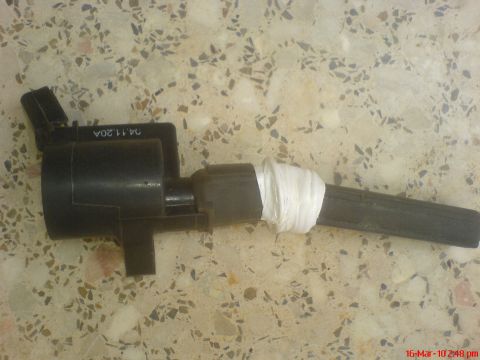 1998 Ford Crown Victoria - A black ignition coil, partially wrapped in white tape, is shown against a speckled background.