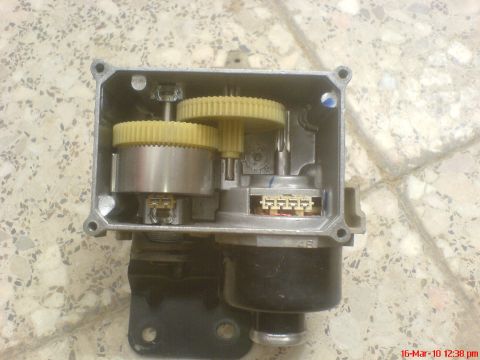 1998 Ford Crown Victoria - Internal view of a cruise control actuator with visible gears and wiring harness connector.