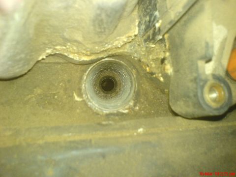 1998 Ford Crown Victoria - This image shows a close-up view of a circular opening within a dirty, metallic engine component.