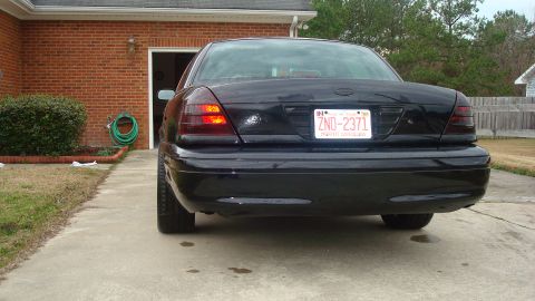 2004 Ford Crown Victoria - Rear view of a black 2004 Ford Crown Victoria parked in a driveway.
