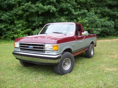 1990 Ford F-150 - Two-tone red and gray 1990 Ford F-150 pickup truck with aftermarket wheels.