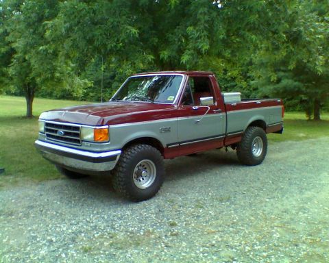 1990 Ford F-150 - This two-tone Ford F-150 pickup truck is shown from a three-quarter front angle on a gravel surface.