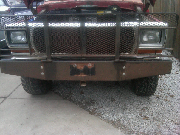 Front view of a rusty 1979 Ford F-Series truck with a large metal grille guard and aftermarket bumper