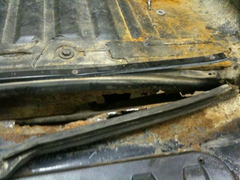 1993 Ford Bronco - This image shows severe rust damage on a vehicle's floor pan, indicating structural compromise.