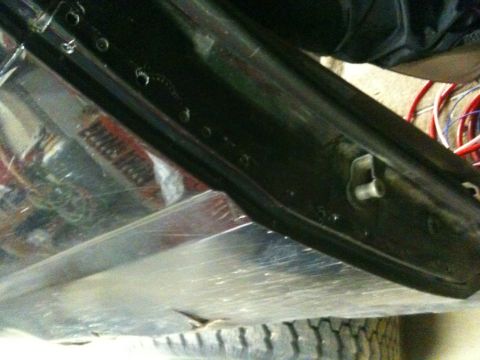 1993 Ford Bronco - Close-up view of a vehicle's undercarriage, showing rust and exposed wiring, with a tire visible.
