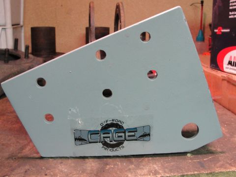 1995 Ford Bronco - A metal bracket with a sticker from Cage Off-Road Products is shown in a workshop setting.