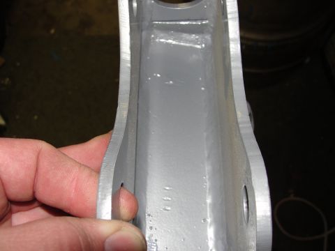 1995 Ford Bronco - Close-up of a gray metal bracket, possibly a vehicle part, with a hand visible.