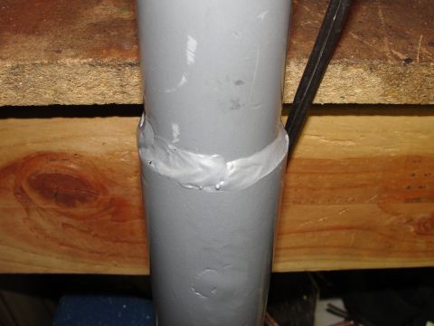1995 Ford Bronco - A close-up view shows a gray pipe with a welded band, positioned against a wooden background.