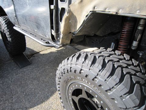 1996 Ford Bronco - Close-up view of the side of a modified off-road vehicle, highlighting its tires and suspension components.
