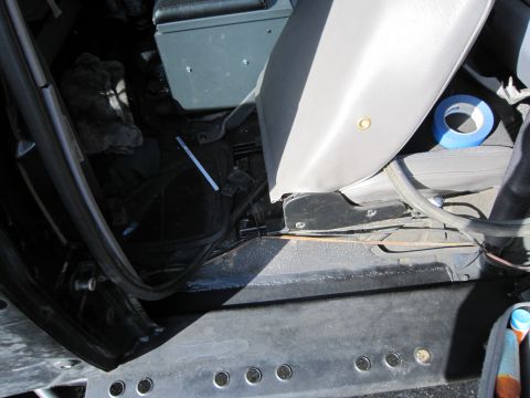 1996 Ford Bronco - Close-up view of the interior floor and seat of a vehicle, with blue tape on the seat.