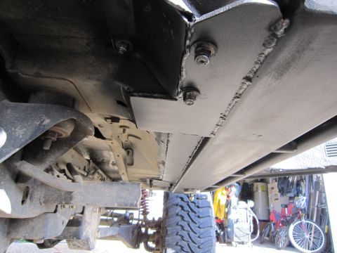 1996 Ford Bronco - Custom rock sliders installed on the underbody of a vehicle, with a large off-road tire visible.