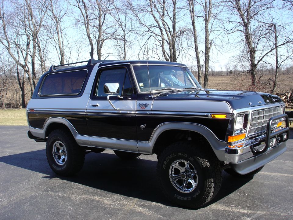 Black and silver Ford Bronco with chrome wheels and a brush guard