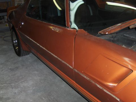 1980 Chevrolet Camaro - The side profile of an orange vehicle is shown, with the hood area visible in the foreground.