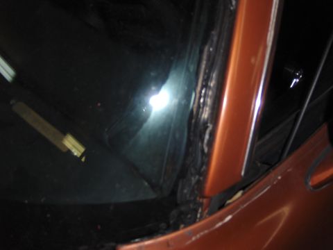 1980 Chevrolet Camaro - Close-up view of the A-pillar and windshield seal on an orange car.